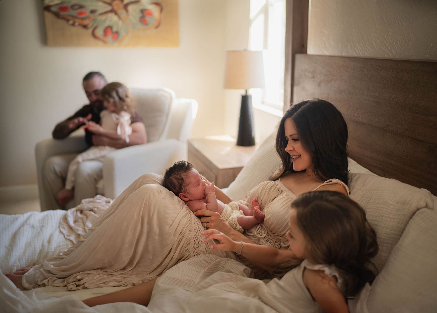 A tender family moment captured in soft lighting on a bed.