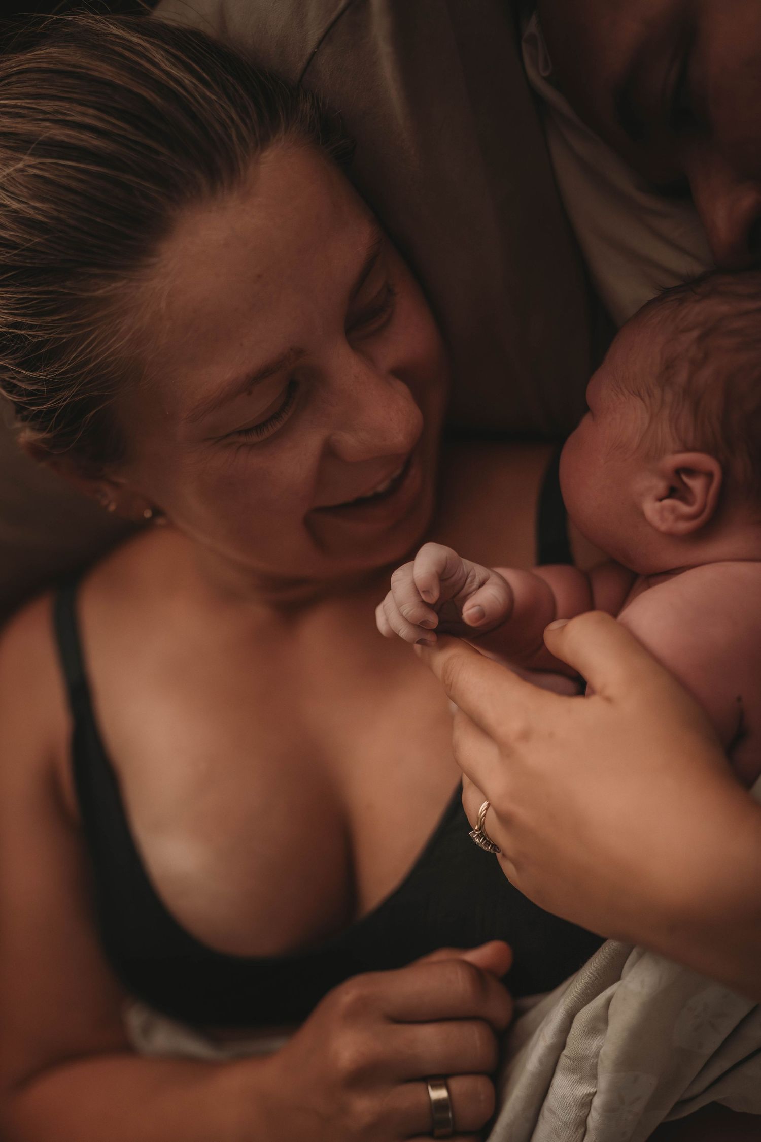 An intimate moment captured between a caregiver and newborn baby sharing a joyful connection.