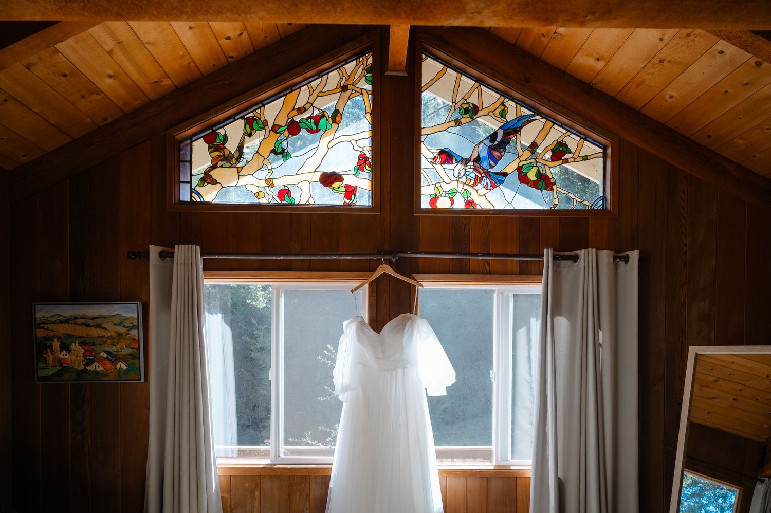 A rustic wooden cabin interior with exposed beams and stained glass windows creating a warm, cozy atmosphere.