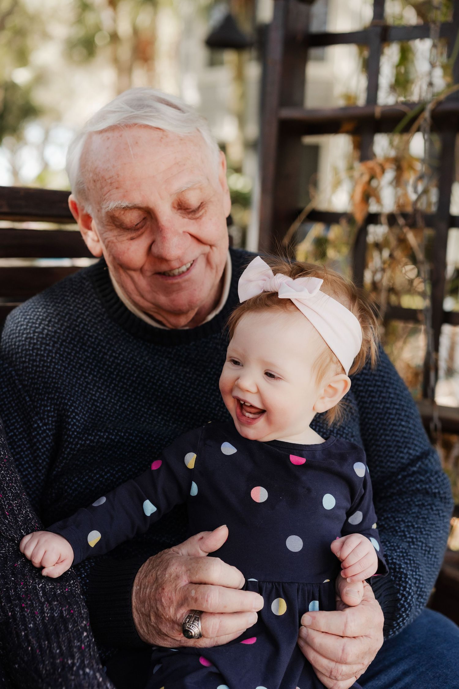 A heartwarming series of candid moments between a baby in polka dot dress and someone in a navy sweater.
