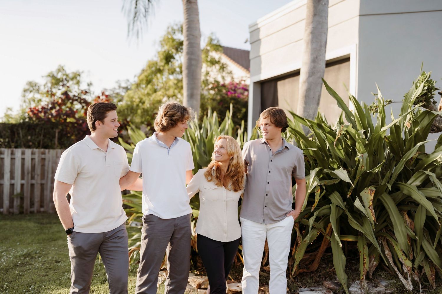 Group of people walking together on a sunny day wearing coordinated white and neutral colored outfits.