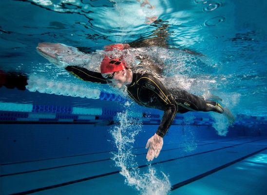 Underwater sequence of competitive swimmer performing butterfly stroke in a pool lane during training session.