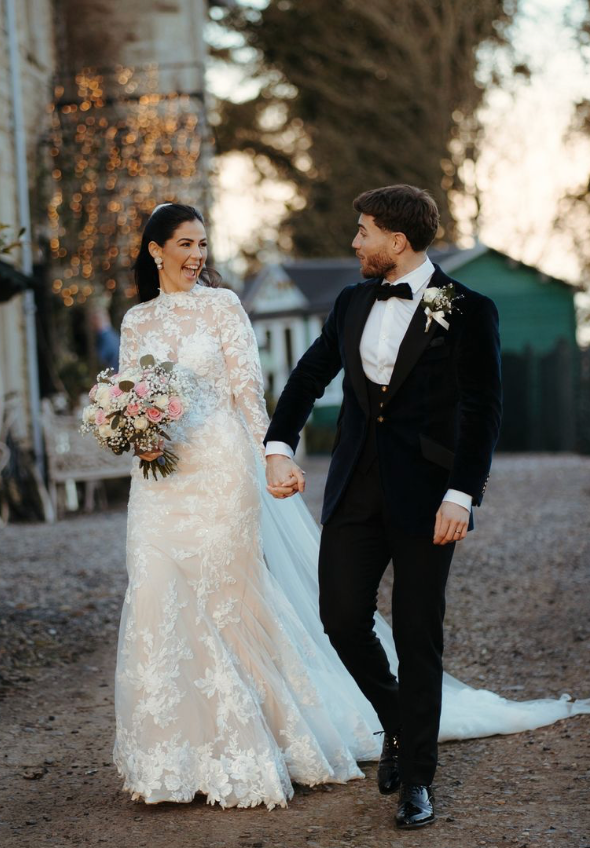 Romantic wedding couple shares candid moments in formal attire during outdoor autumn photoshoot.