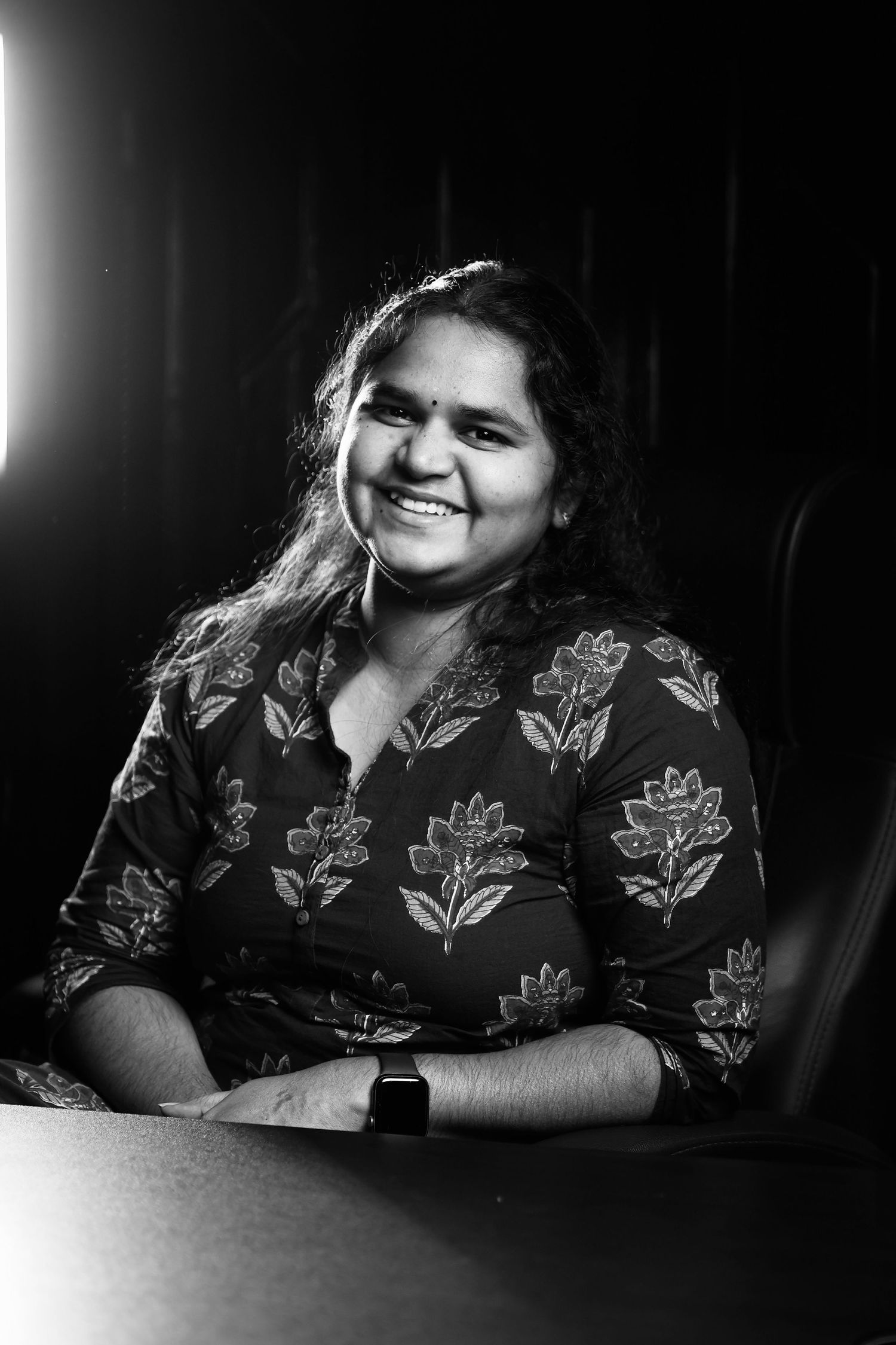Black and white portrait of Sreevalli, Co-founder of Jeno Photography in floral print with natural lighting.