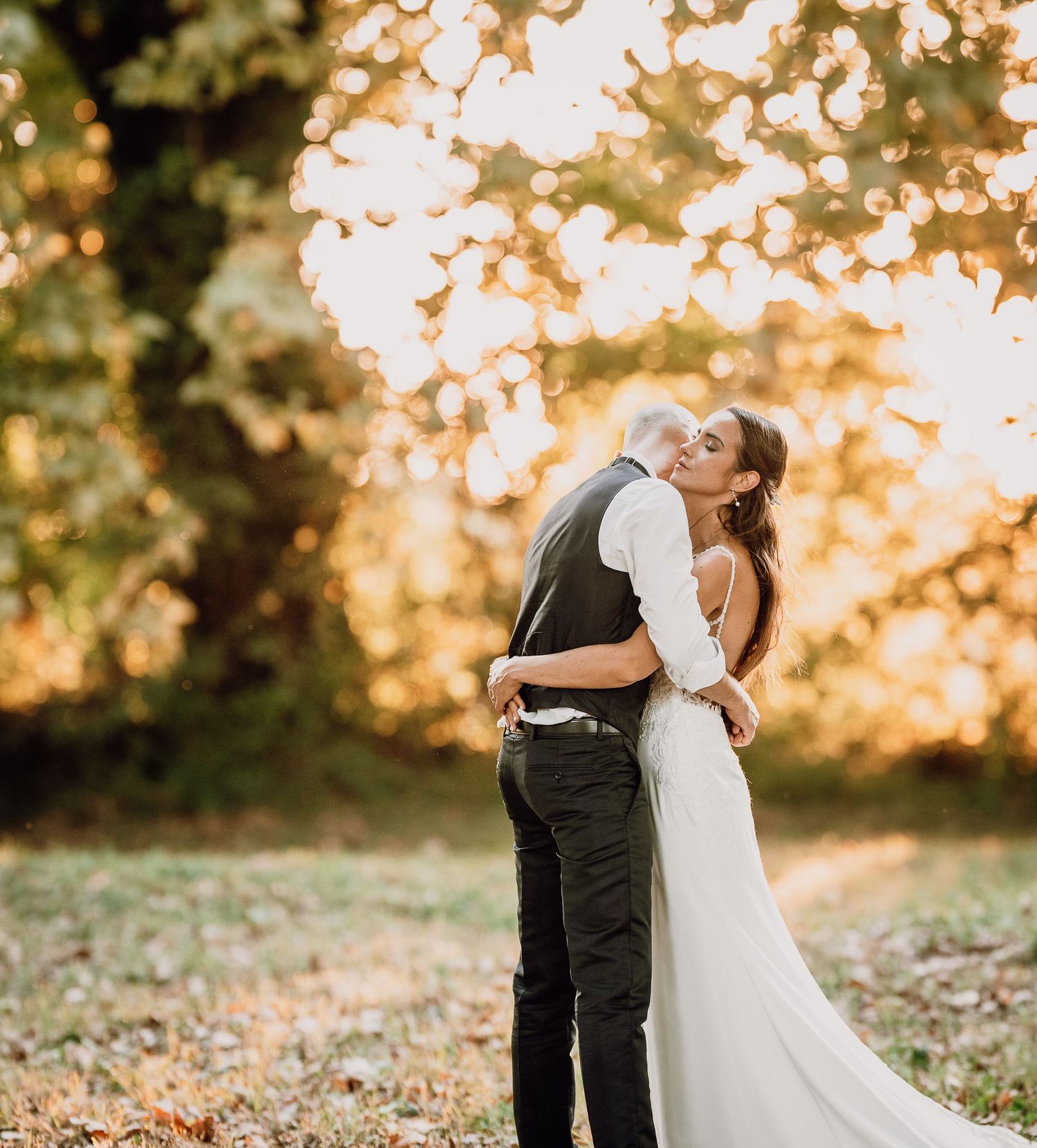 A couple shares a romantic sunset moment in a garden setting during their wedding celebration.