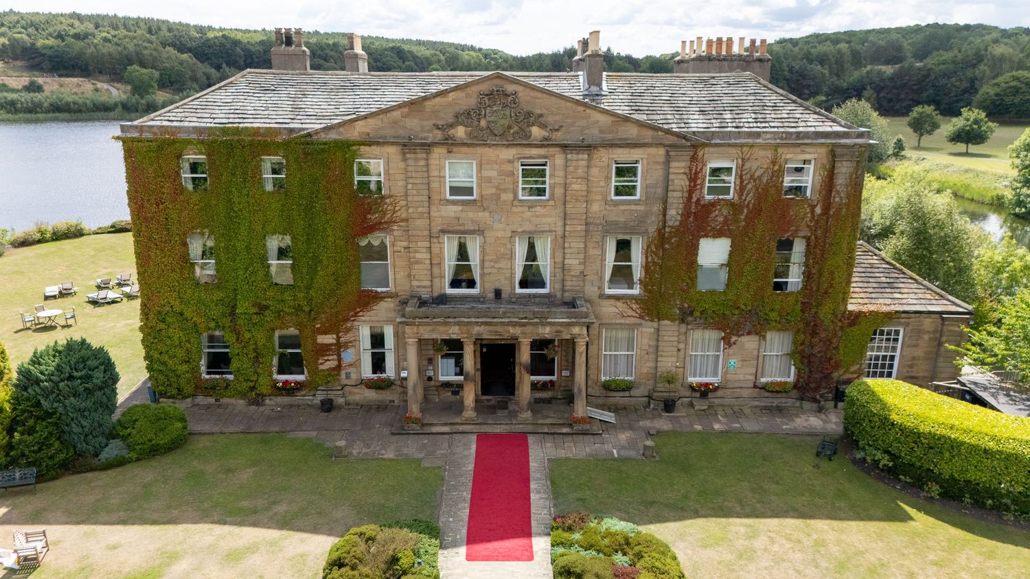 Waterton Park Hotel - Panoramic view of a grand ivy-covered stone mansion with manicured gardens.