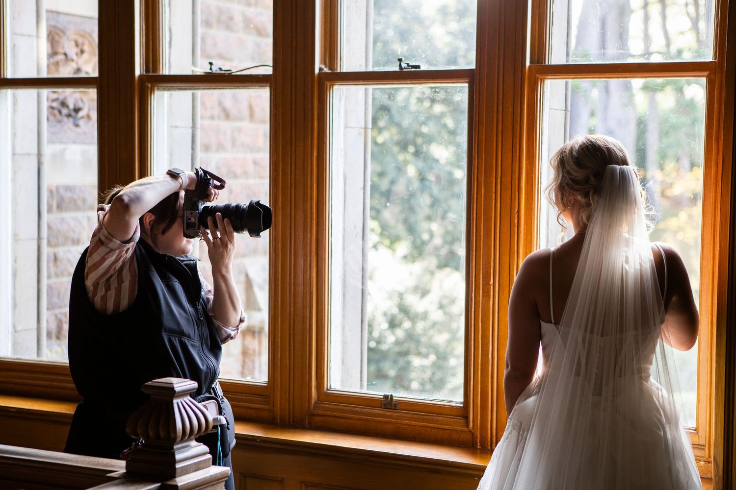 Rushpool Hall - Wedding photographer captures intimate moments through a series of window-framed shots in warm natural lighting.
