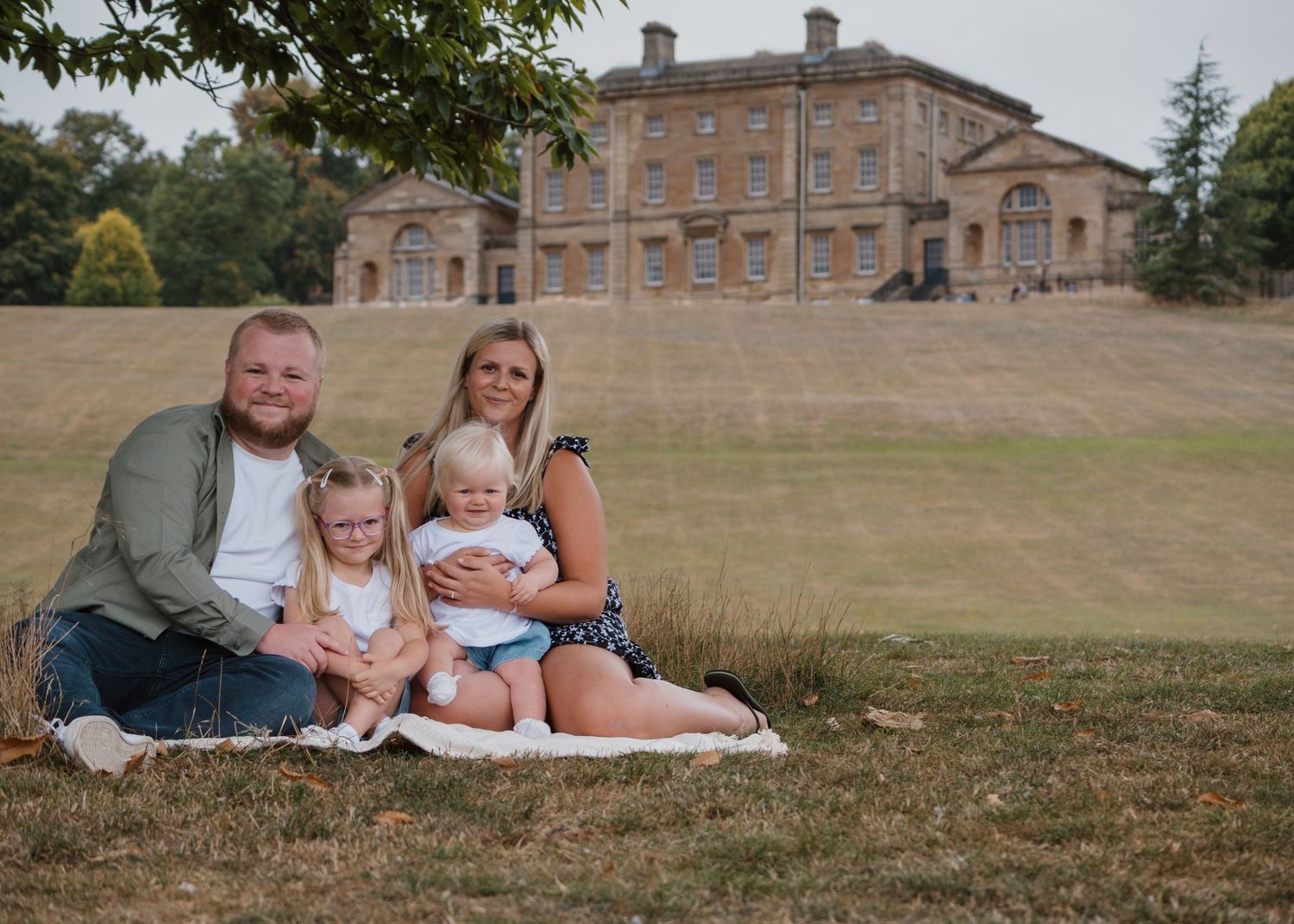 Family Photoshoot - Cusworth Hall - Family group relaxing on blanket with historic mansion in background.