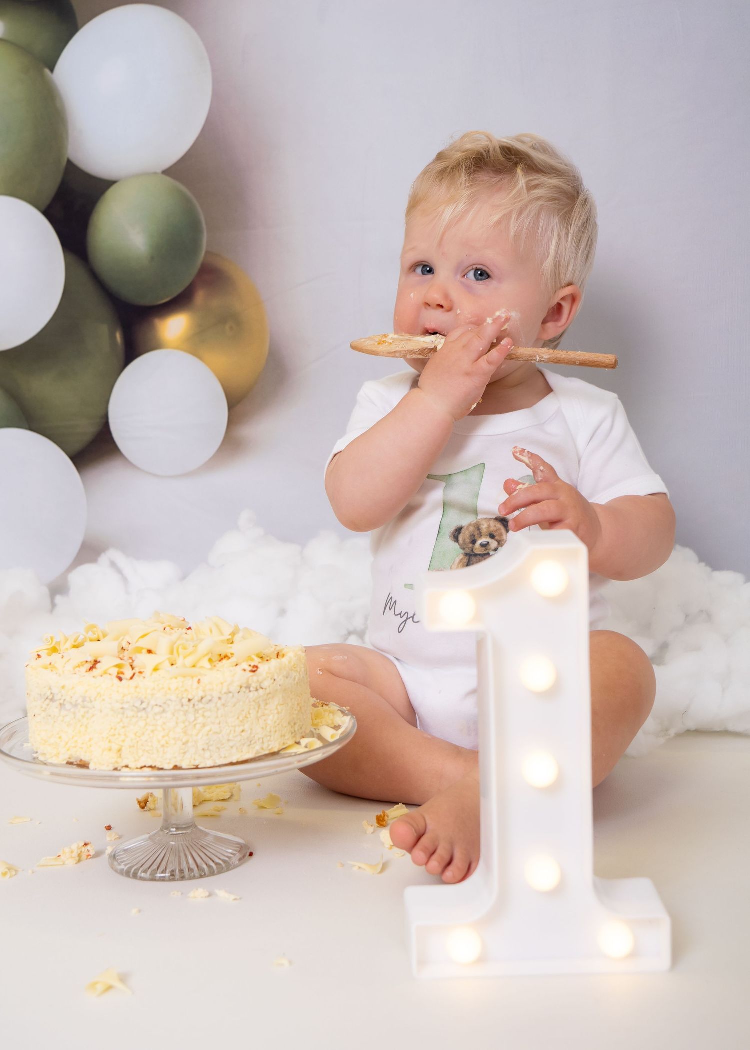 Cake smash photo session with illuminated number one and scattered cake crumbs. Cake Smash Photoshoot