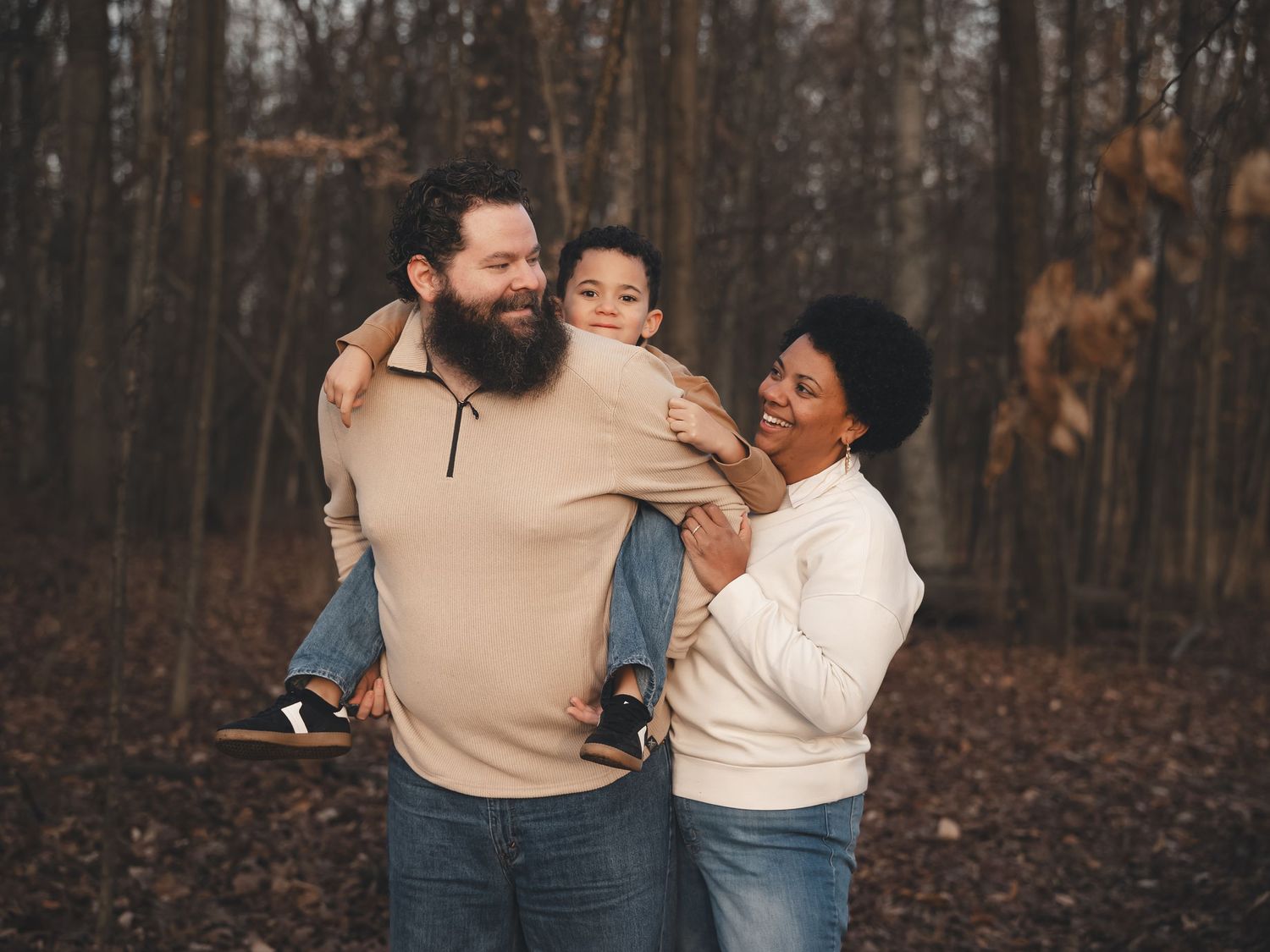 A warm family session in the woods of Northeast Ohio, capturing genuine smiles, playful moments, and love in the late autumn light.