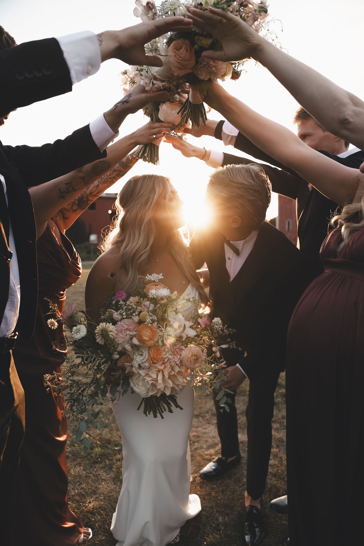 Sunset celebration at Wildflower Woods in Fredericktown, Ohio—joyful wedding party tunnel filled with flowers, warmth, and candid laughter.