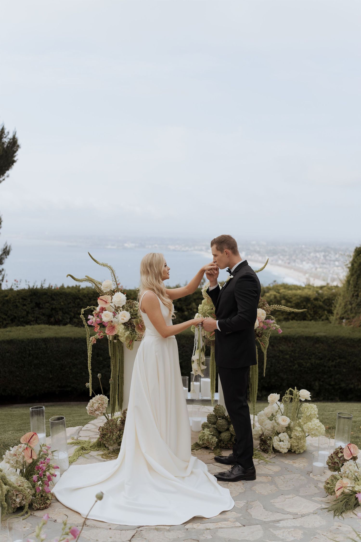 Bride and groom first kiss during romantic outdoor wedding ceremony