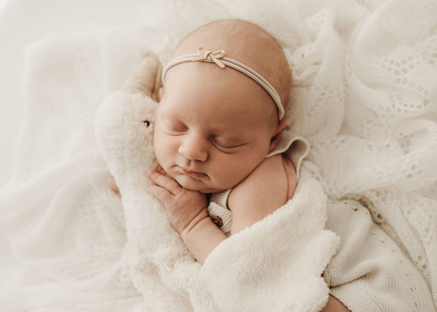 Beautiful newborn portrait captured in natural neutral tones.