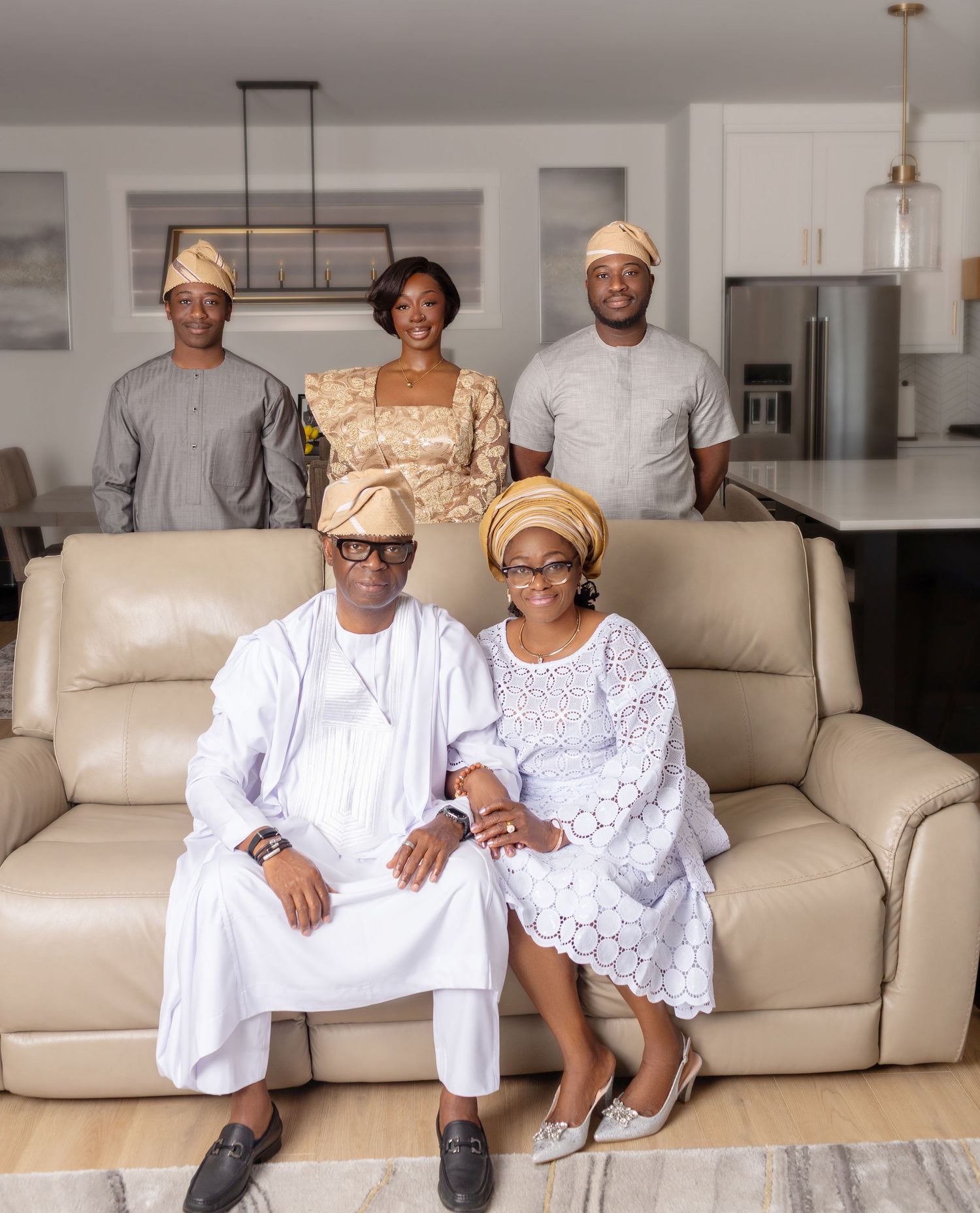 Family of five in Nigerian traditional wear posing in elegant home interior.