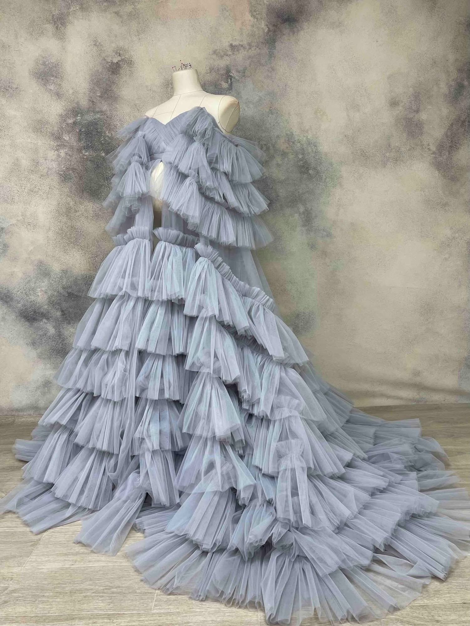 Elegant dusty blue tiered ruffle tulle maternity gown on a mannequin.