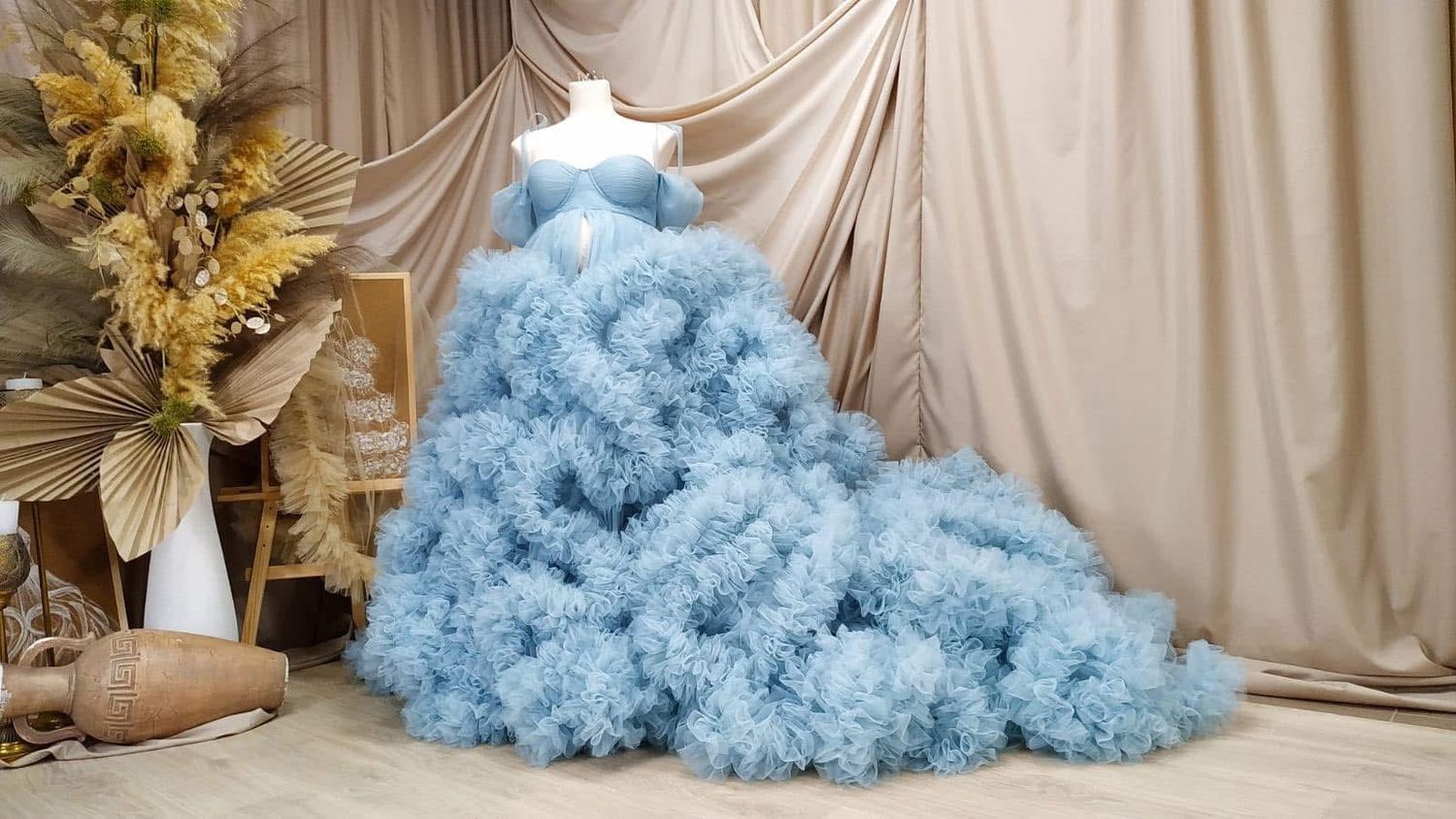 Fluffy light blue cloud-like tulle maternity ball gown on a mannequin.