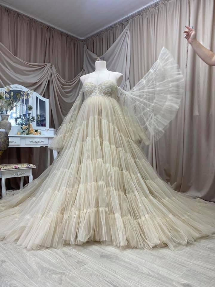 Elegant champagne tiered tulle ballgown with butterfly sleeves and beaded bodice displayed on mannequin.