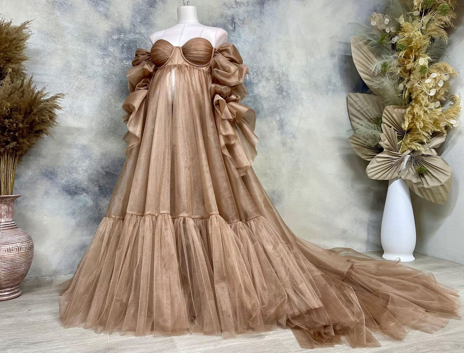 Caramel brown strapless tulle maternity ballgown with puff sleeves and tiered skirt on mannequin.