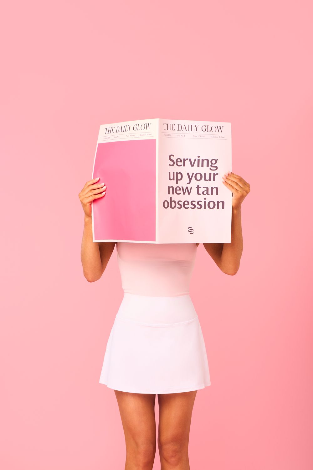 Woman in white mini skirt holding The Daily Glow newspaper with headline about tan obsession on pink background.
