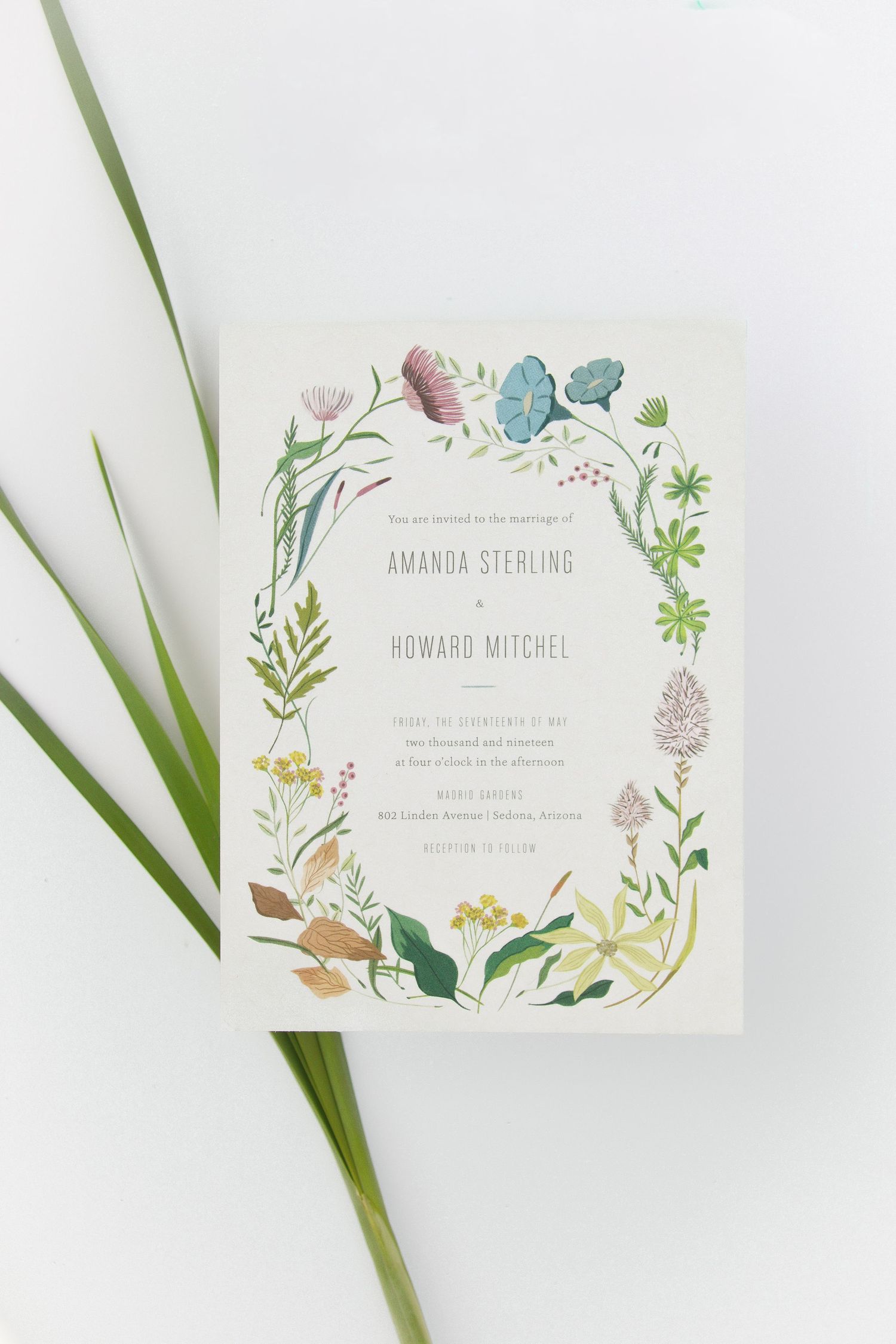 Elegant floral wedding place cards with botanical illustrations and green palm leaves on white background.