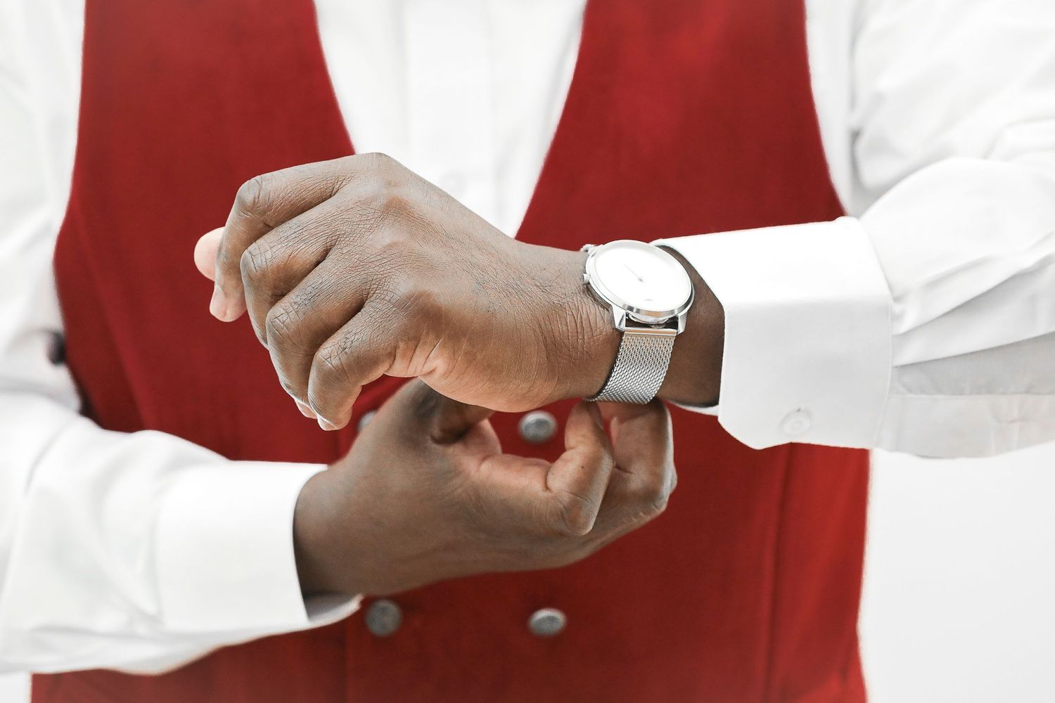 Professional in a red vest and white shirt demonstrates proper hand washing technique in multiple steps.
