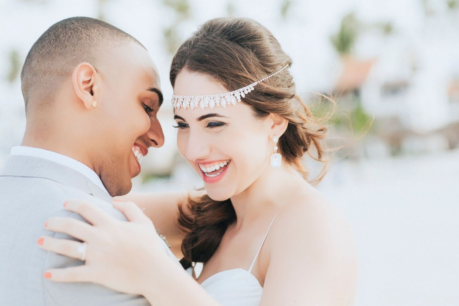 Romantic couple in wedding attire share tender moments in a bright outdoor setting with soft lighting.