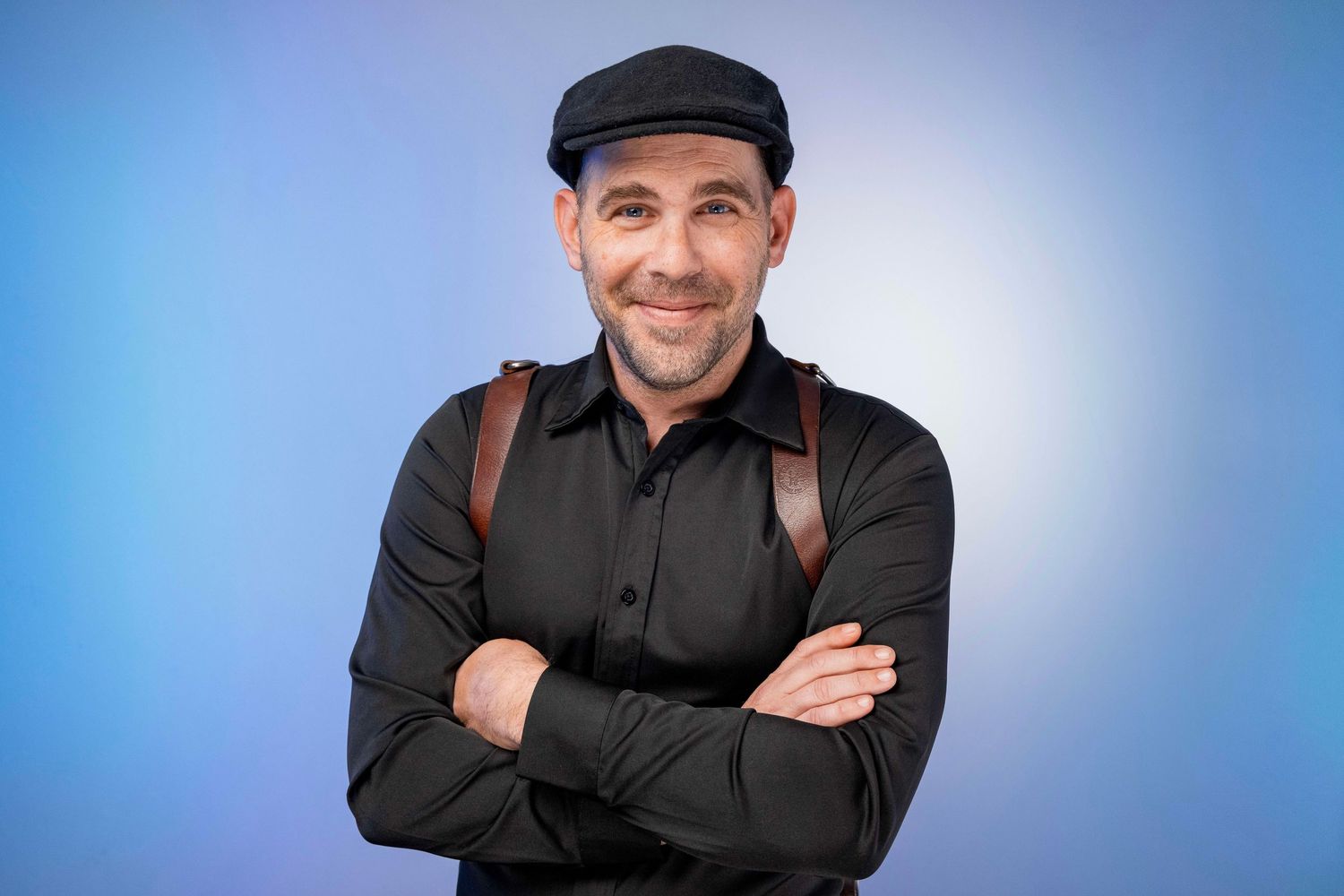 Professional headshot portrait of Jay Grubb in dark clothing against a blue background.