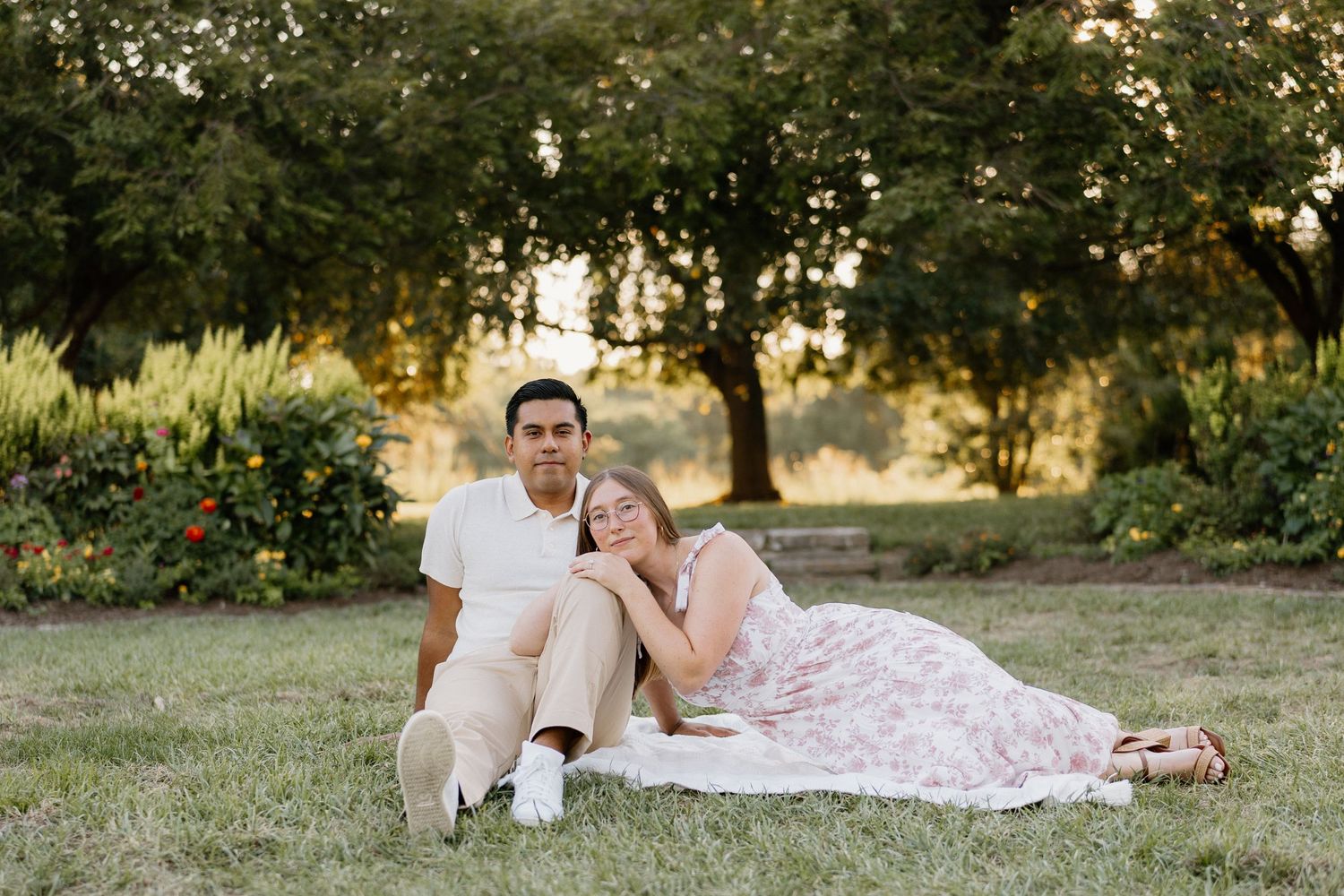 Romantic sunset portrait session in a lush green field with soft golden light filtering through the trees.