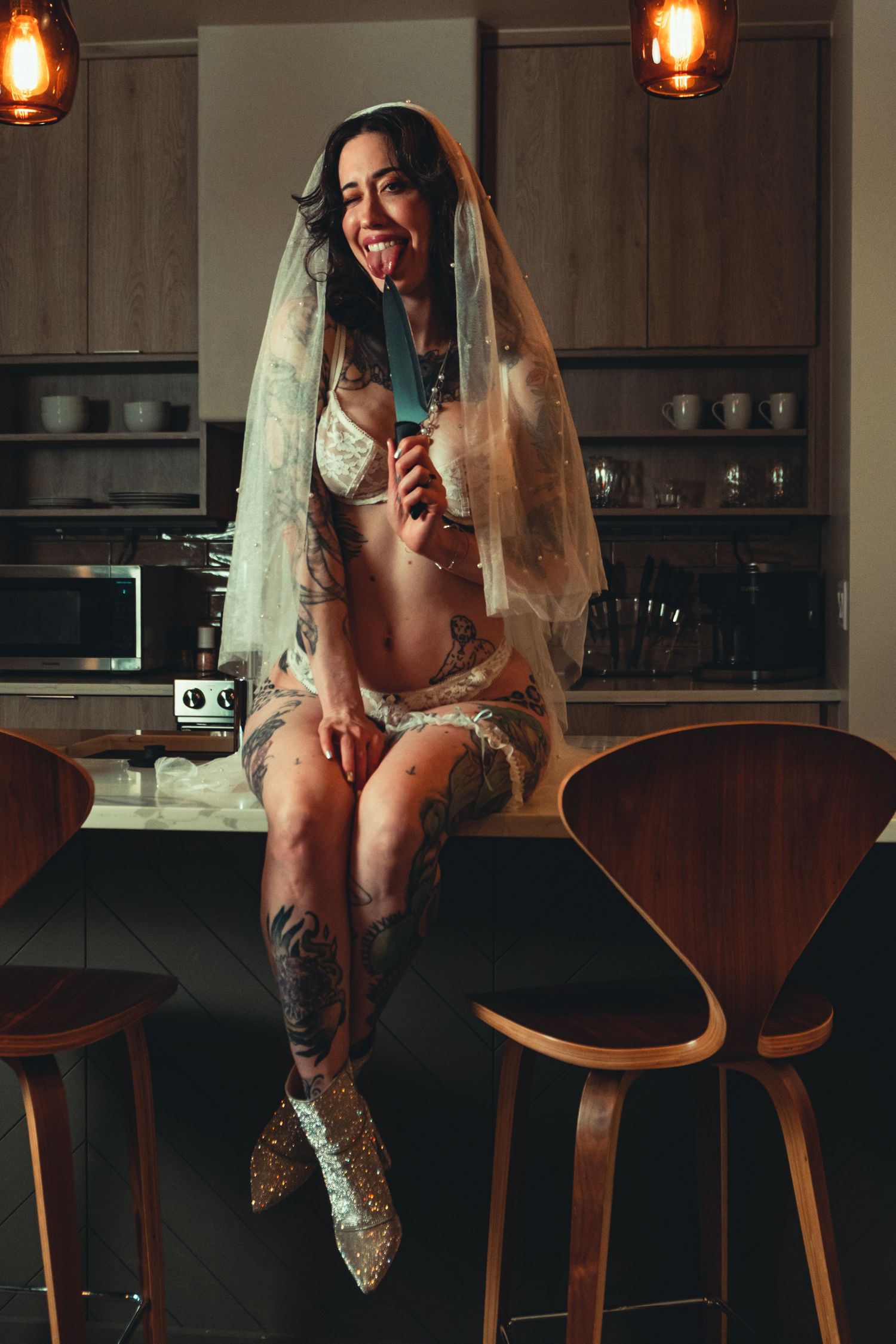 Playful bridal boudoir image showing glittery boots and a glass of wine in a contemporary kitchen setting.