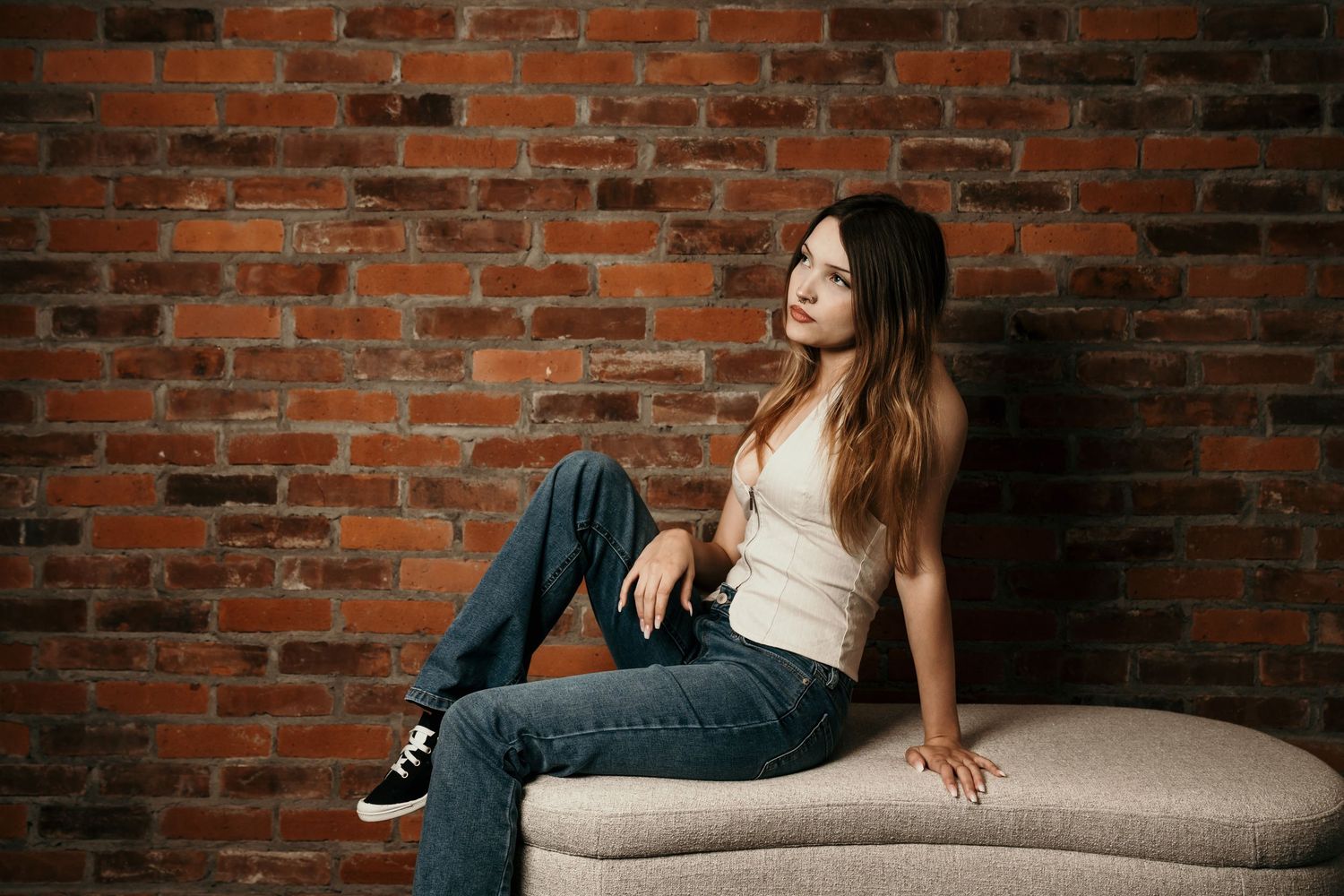 Moody studio portrait with dramatic lighting, deep shadows, and rich contrast, creating an intimate, artistic, and striking image.