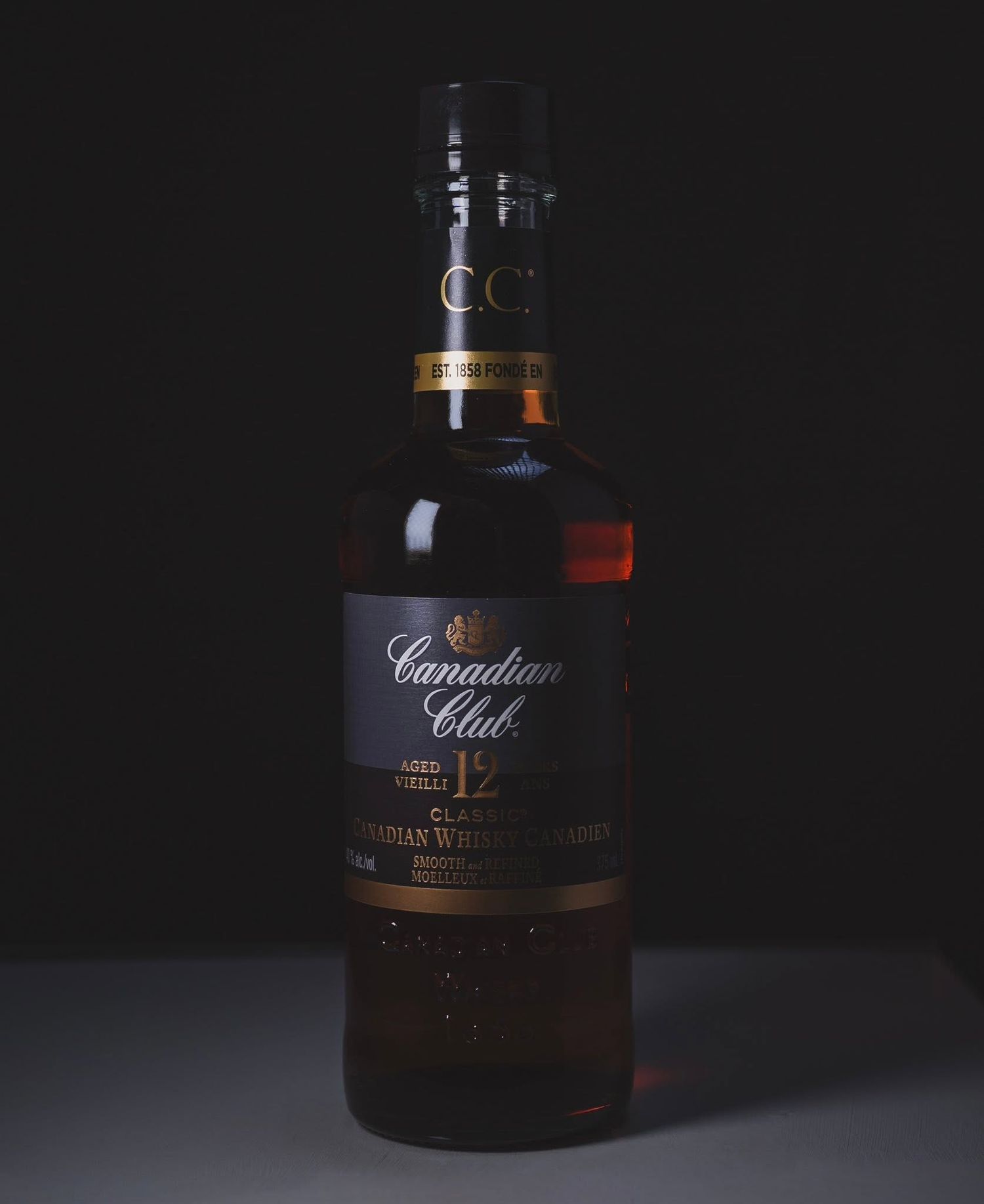 Whiskey bottle photographed with dramatic lighting, rich shadows, and a moody backdrop, creating a bold and sophisticated product image.