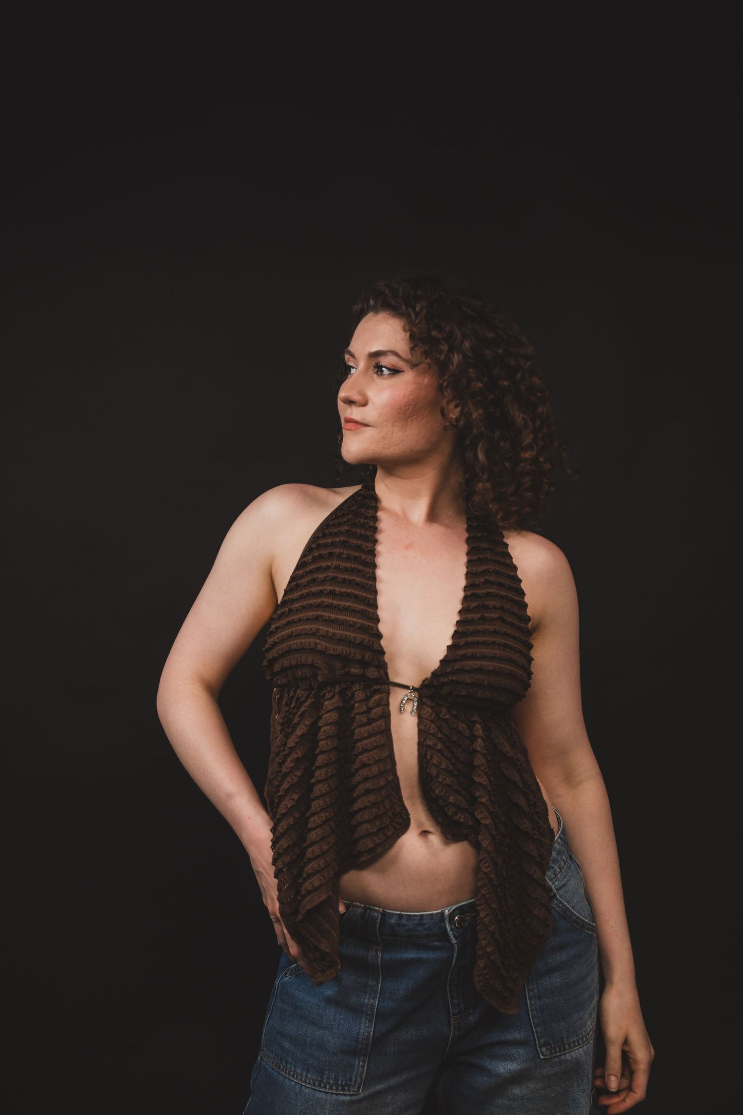 Moody studio portrait with dramatic lighting, deep shadows, and rich contrast, creating an intimate, artistic, and striking image.