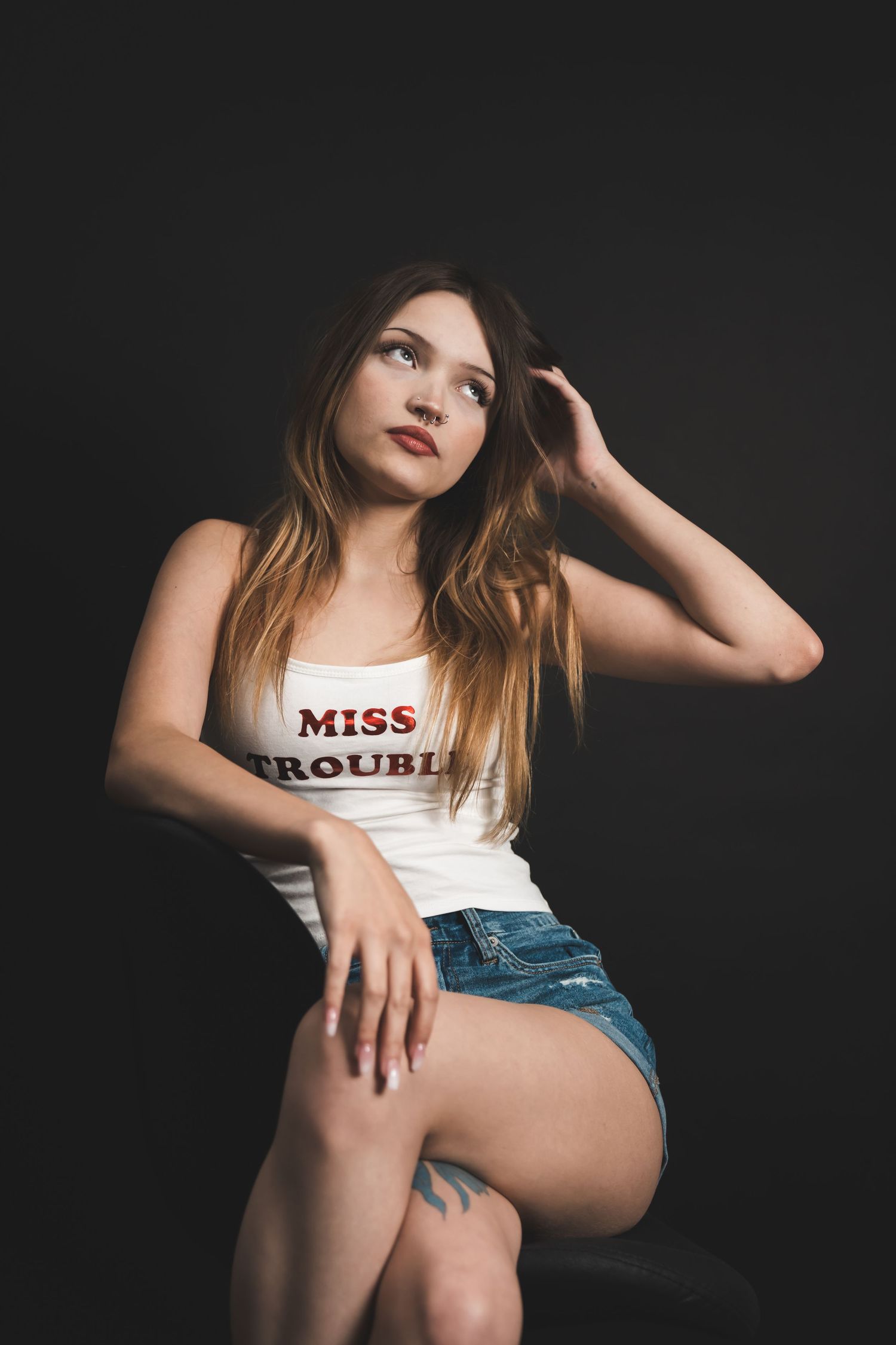 Moody studio portrait with dramatic lighting, deep shadows, and rich contrast, creating an intimate, artistic, and striking image.