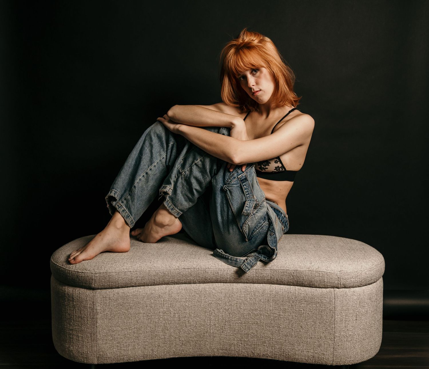 Moody studio portrait with dramatic lighting, deep shadows, and rich contrast, creating an intimate, artistic, and striking image.