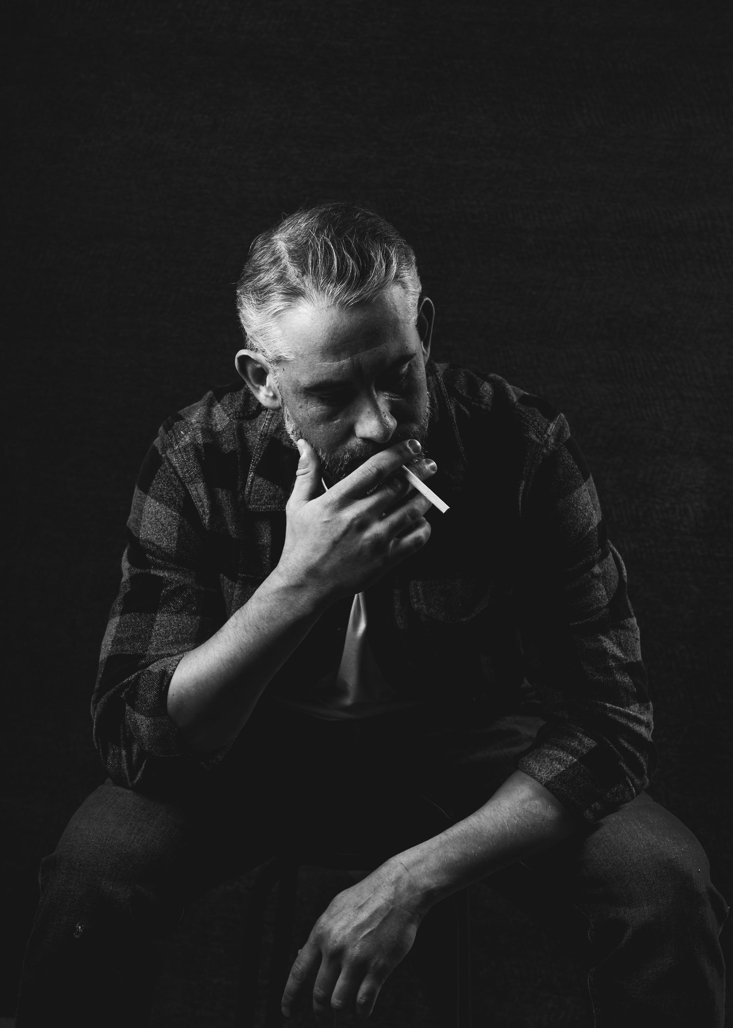Moody studio portrait with dramatic lighting, deep shadows, and rich contrast, creating an intimate, artistic, and striking image.
