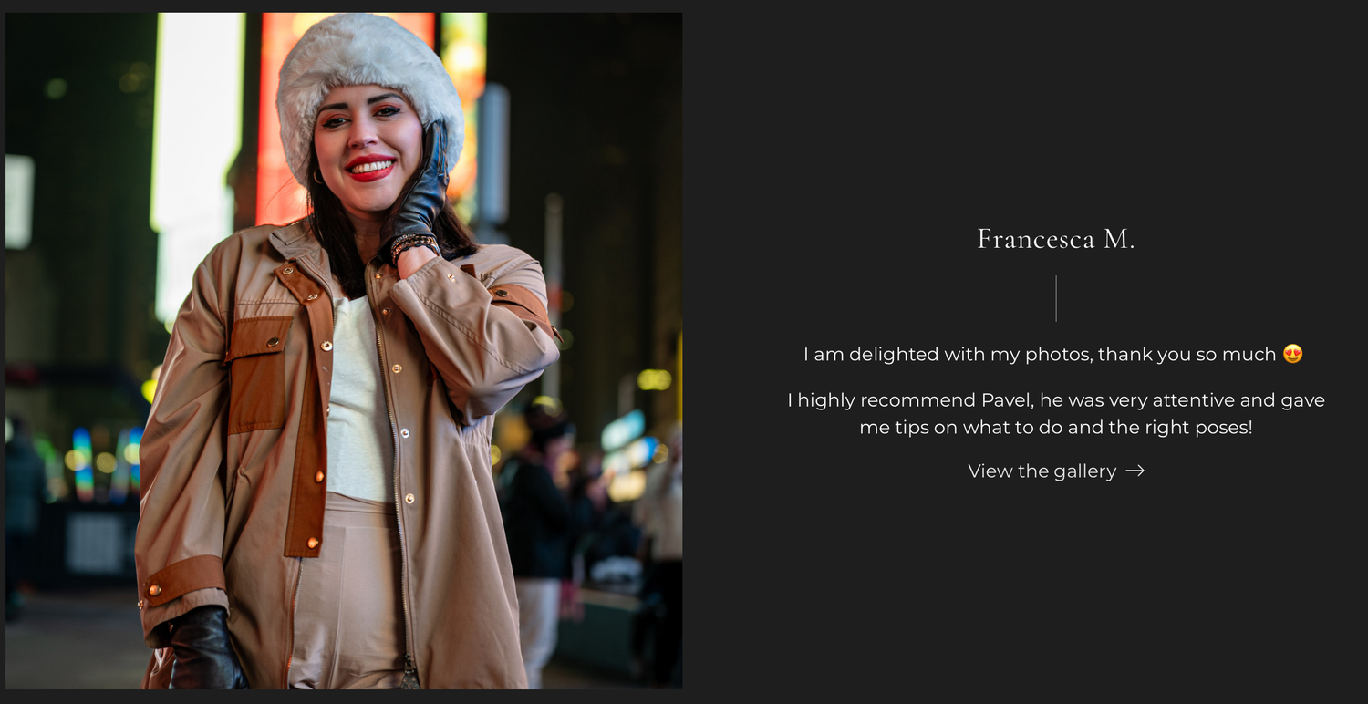 A smiling woman in a fur hat and beige coat poses confidently outdoors at night in a vibrant city setting.