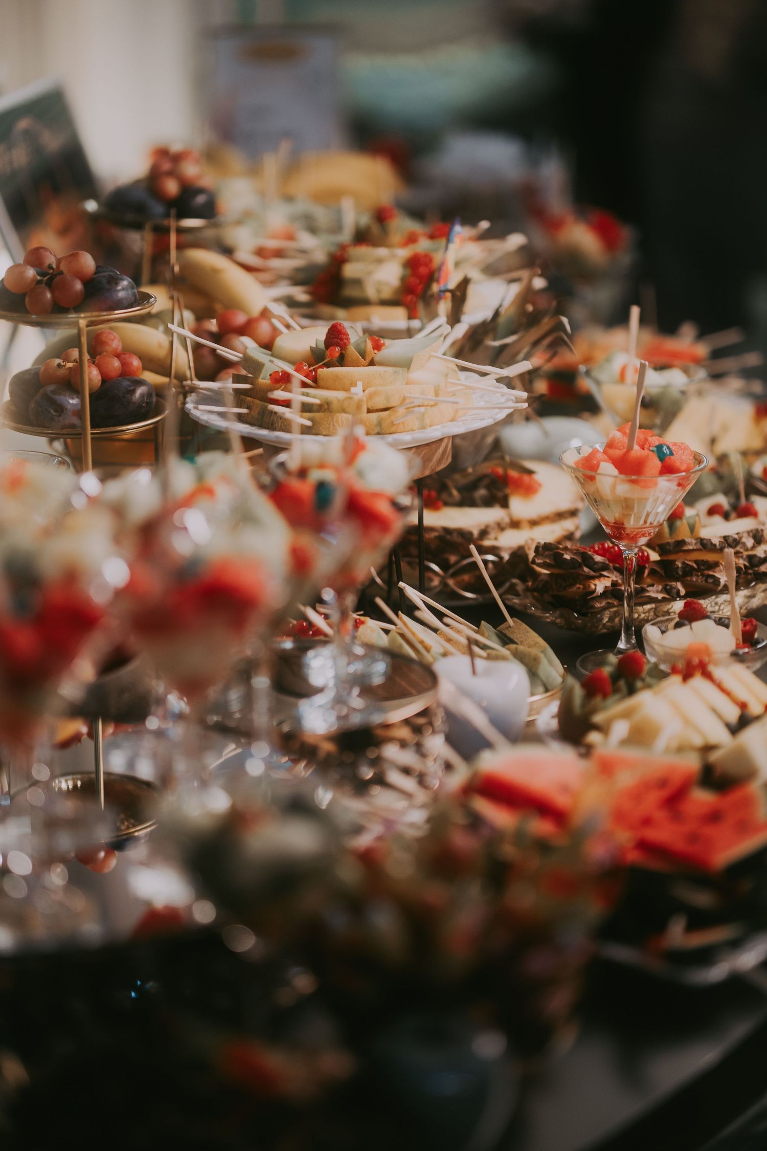 Close-up of lavish wedding catering spread with fruit-topped desserts and appetizers in glasses. Epicu Fotograf Drobeta-Turnu Severin