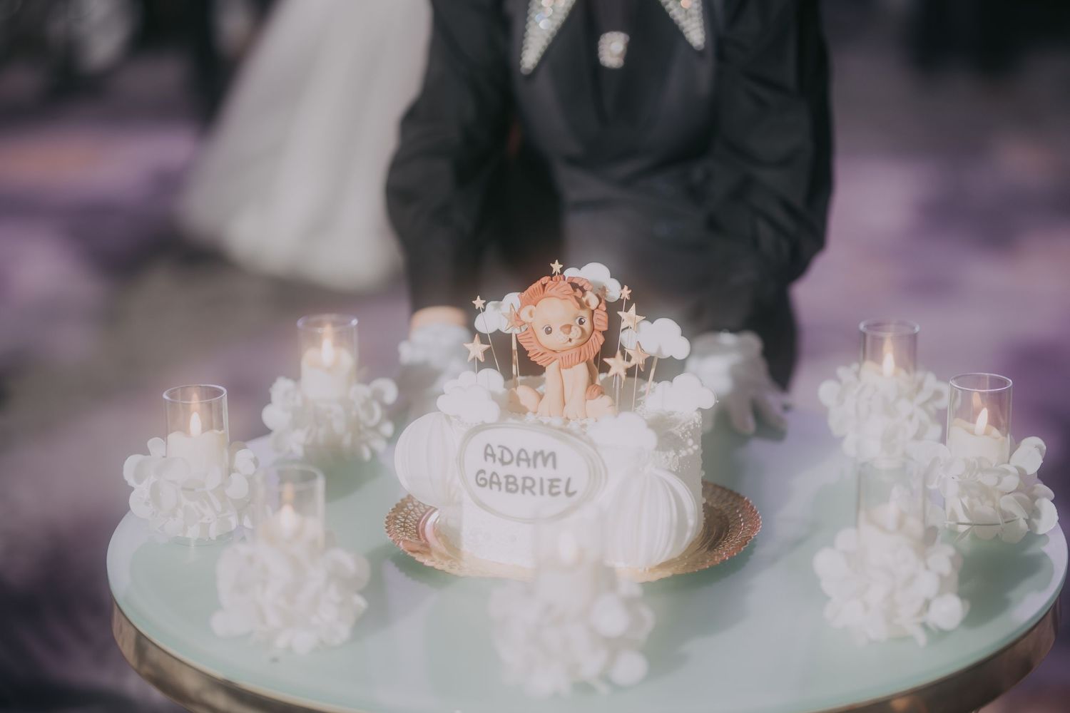 Wedding cake with Adam and Gabriel names surrounded by white flowers and candles on glass table. Epicu Fotograf Drobeta-Turnu Severin