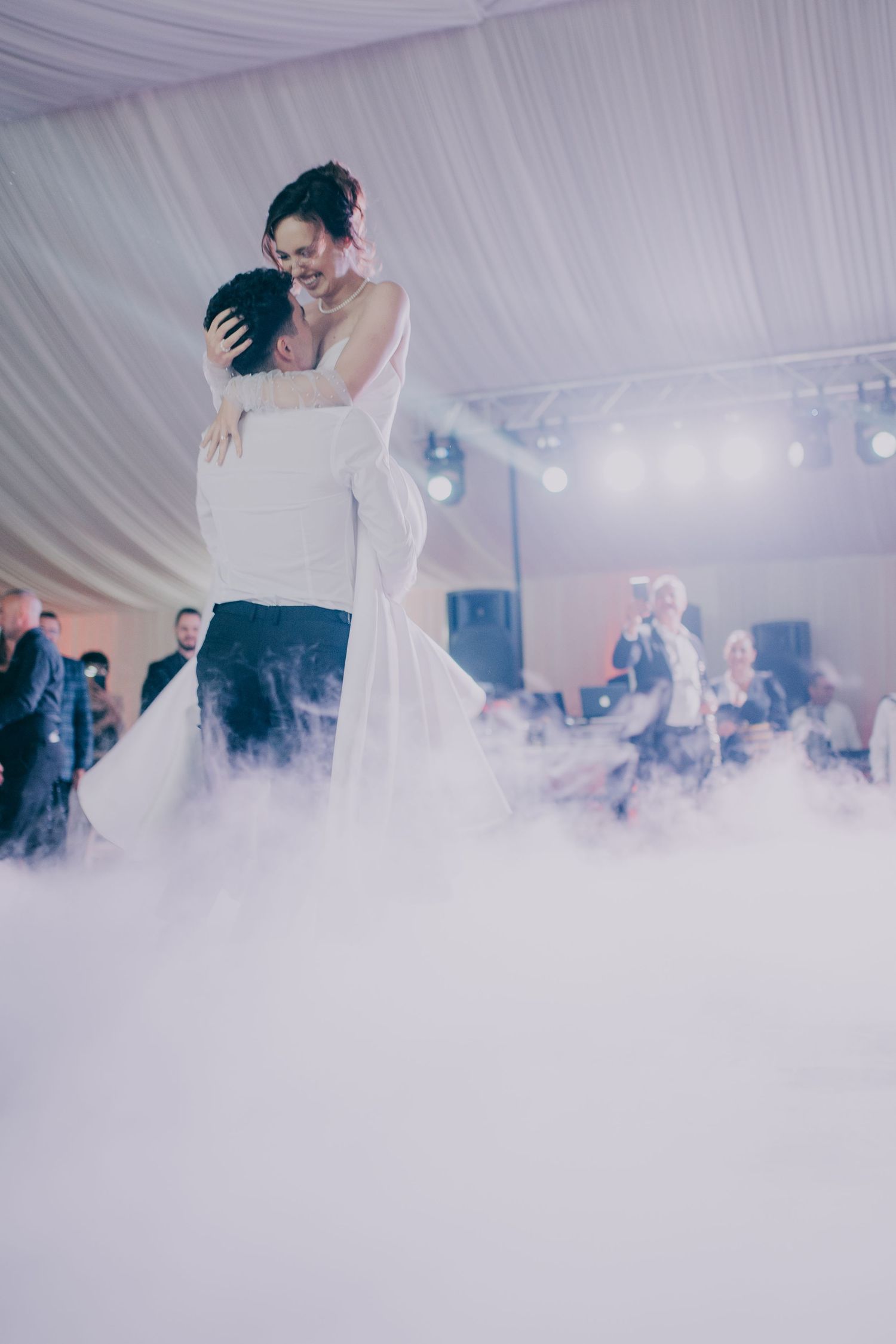Groom lifts bride in wedding dress during romantic first dance surrounded by dramatic fog effects. Epicu Fotograf Drobeta-Turnu Severin