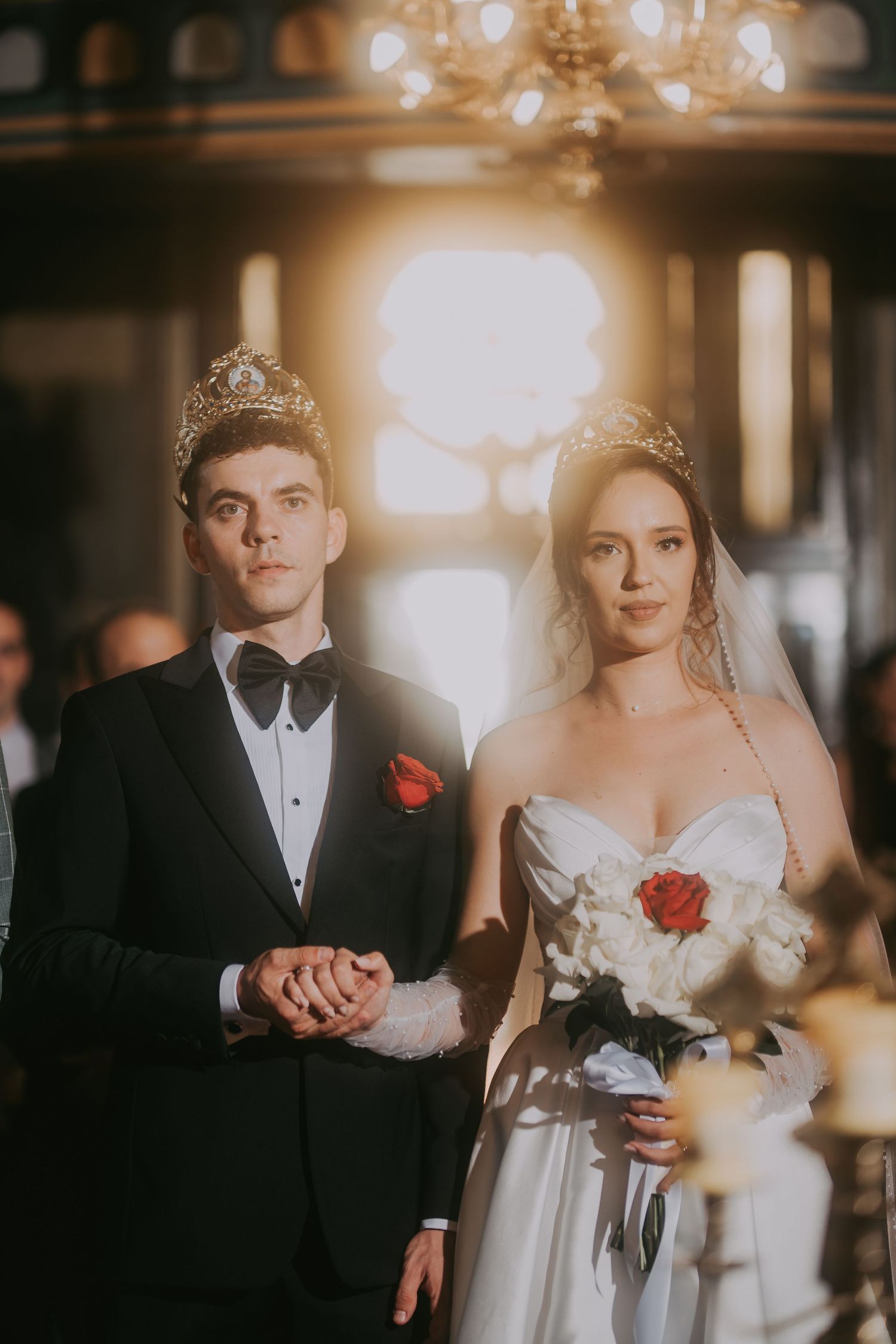 Bride and groom wearing golden crowns during Orthodox wedding ceremony in elegant church. Epicu Fotograf Drobeta-Turnu Severin