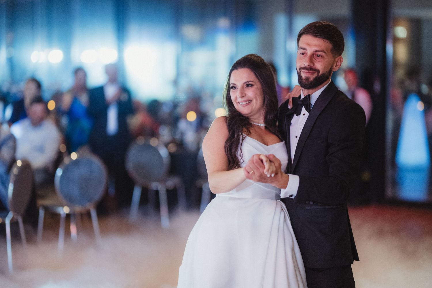 Happy newlyweds share intimate first dance moment at elegant wedding reception venue.