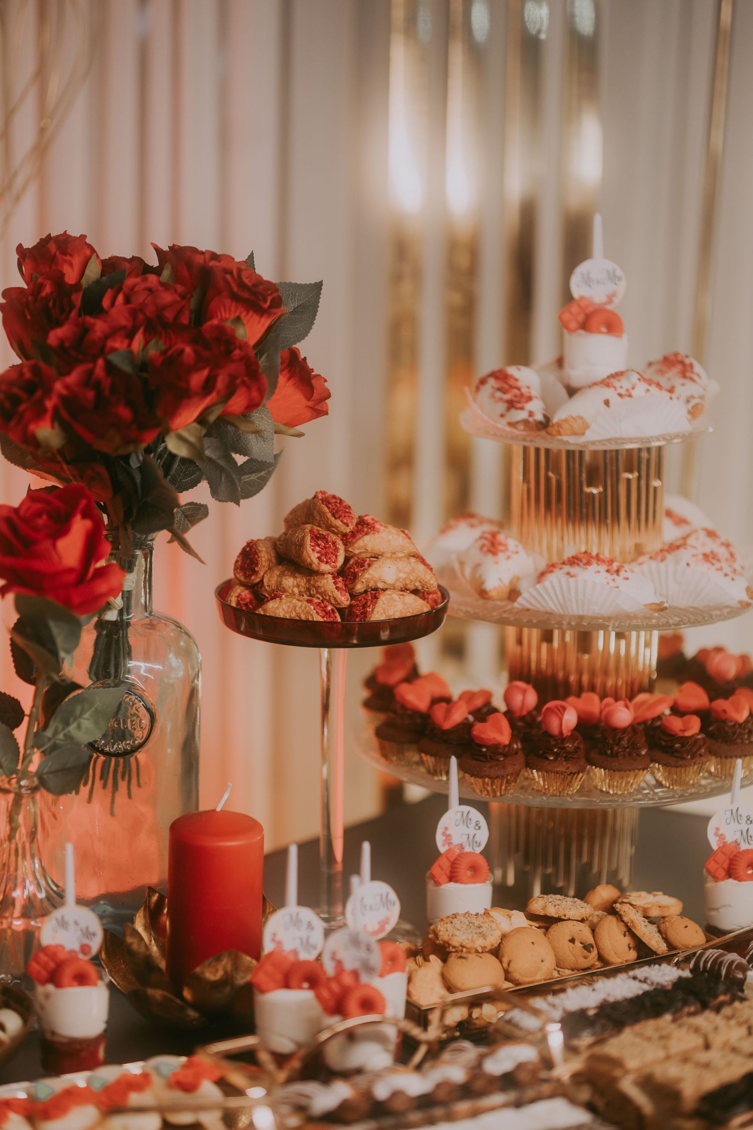 Wedding dessert station with cupcake tower, red roses, candles, and assorted sweet treats. Epicu Fotograf Drobeta-Turnu Severin