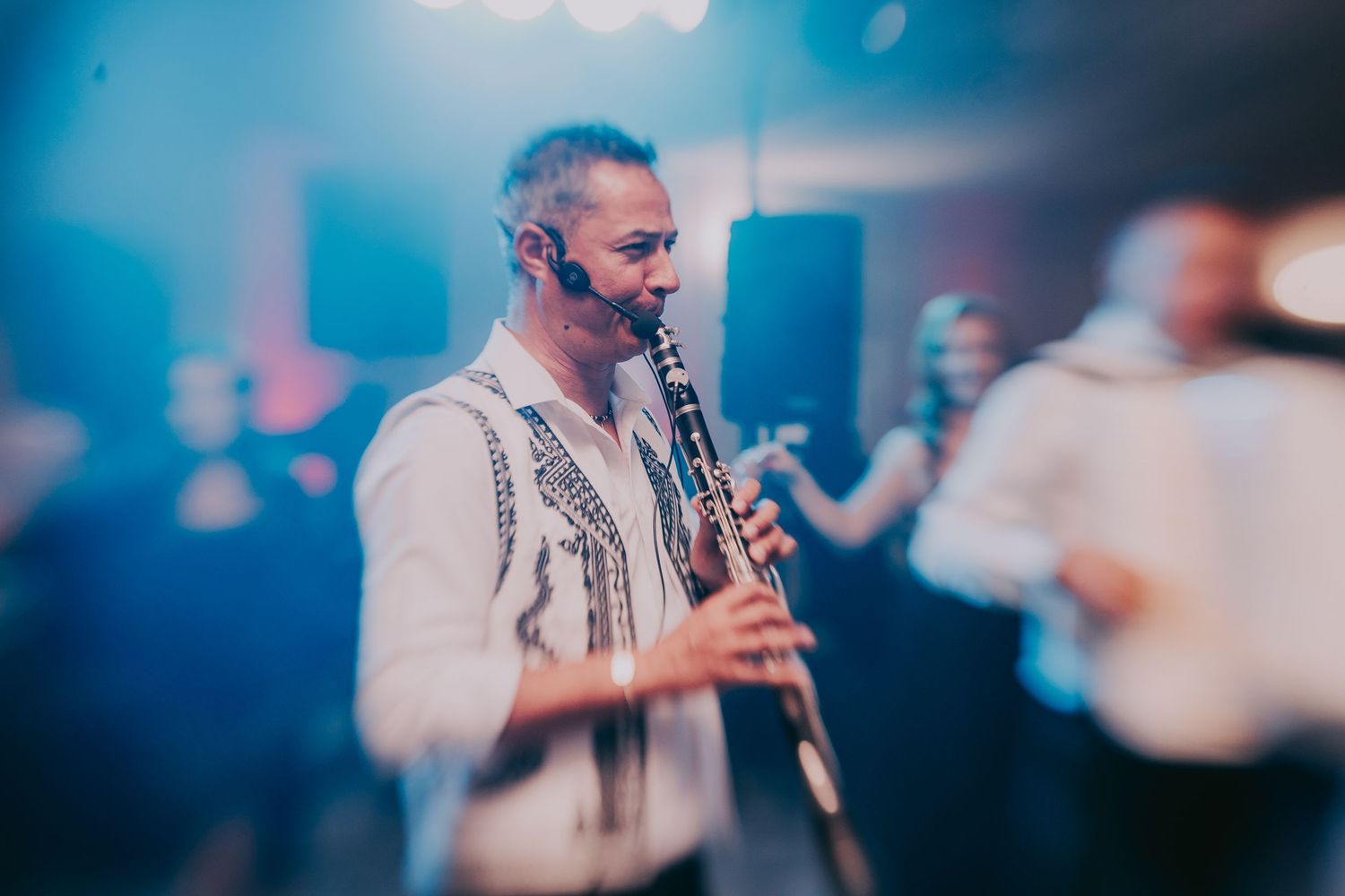 Musician playing clarinet in traditional embroidered shirt at elegant wedding reception. Epicu Fotograf Drobeta-Turnu Severin