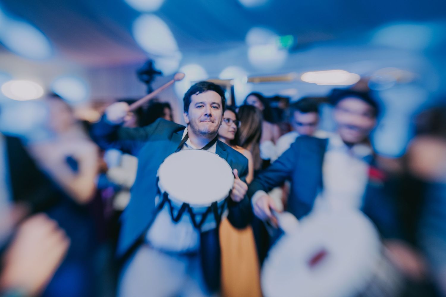 Man playing drum during festive wedding reception with guests dancing in background. Epicu Fotograf Drobeta-Turnu Severin