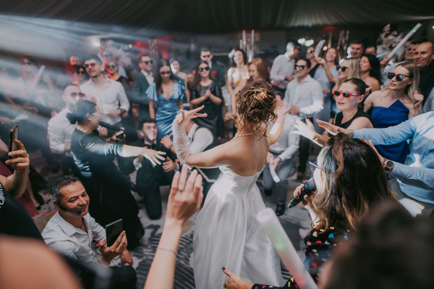 Bride in white wedding dress dancing surrounded by cheering guests at a lively wedding reception party. Epicu Fotograf Drobeta-Turnu Severin