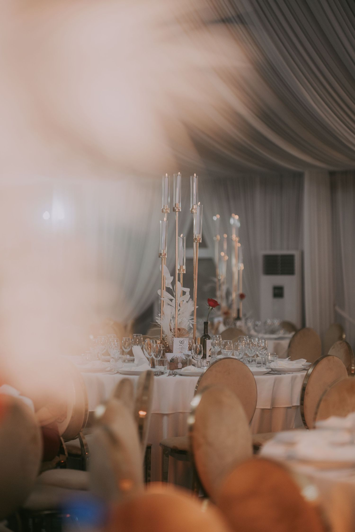 Luxurious wedding reception hall with tall candelabras, white draping, and elegant table settings. Epicu Fotograf Drobeta-Turnu Severin
