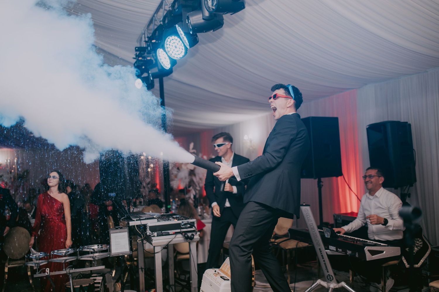 Performer in sunglasses blowing smoke on stage at an energetic live wedding reception show. Epicu Fotograf Drobeta-Turnu Severin