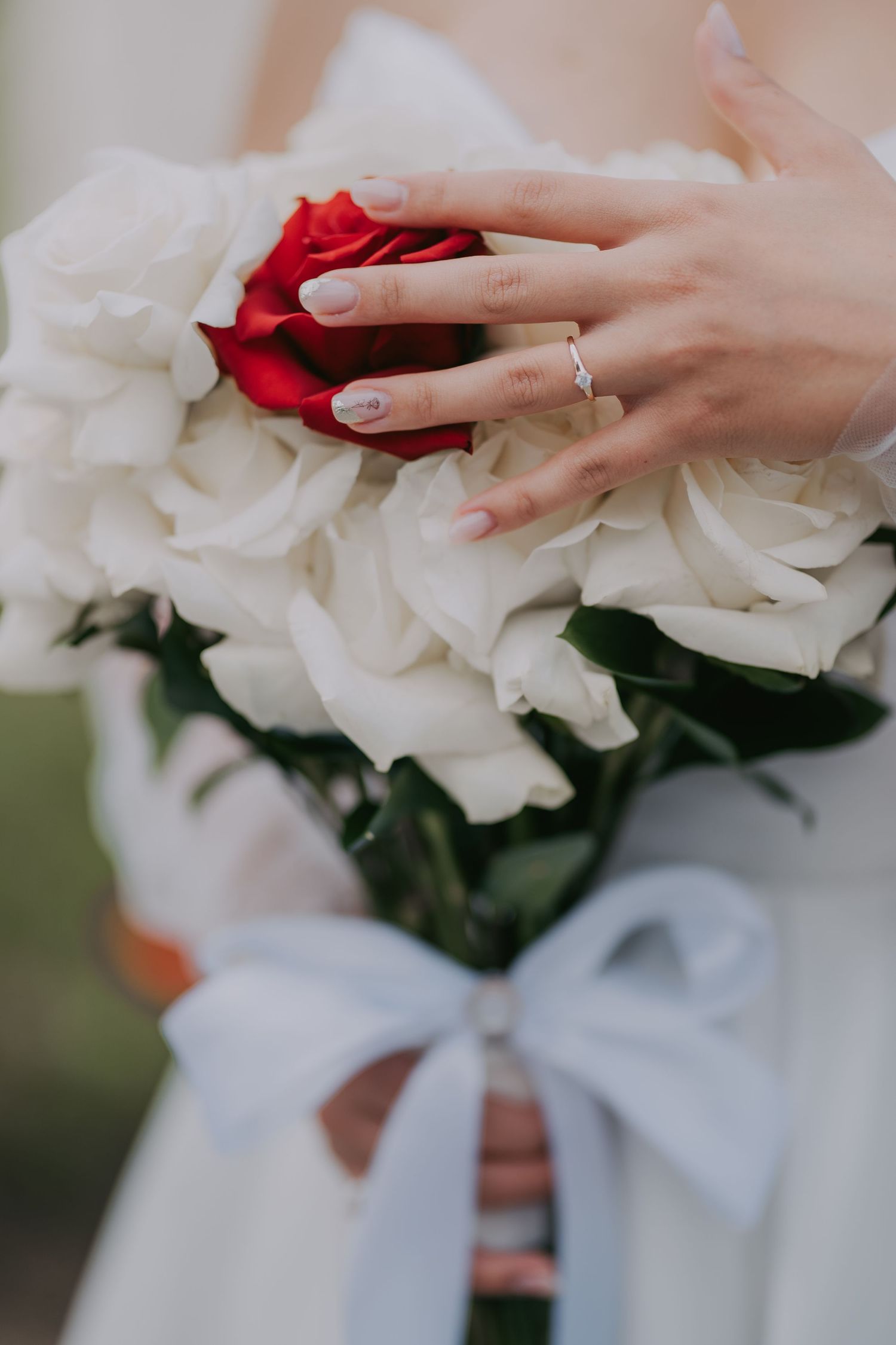 Close-up of bride holding a bouquet of white roses with a single red rose and diamond ring. Epicu Fotograf Drobeta-Turnu Severin
