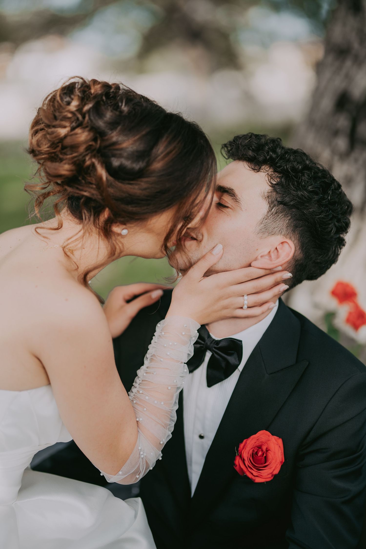 Romantic bride and groom sharing a tender kiss on their wedding day with red rose boutonniere. Epicu Fotograf Drobeta-Turnu Severin