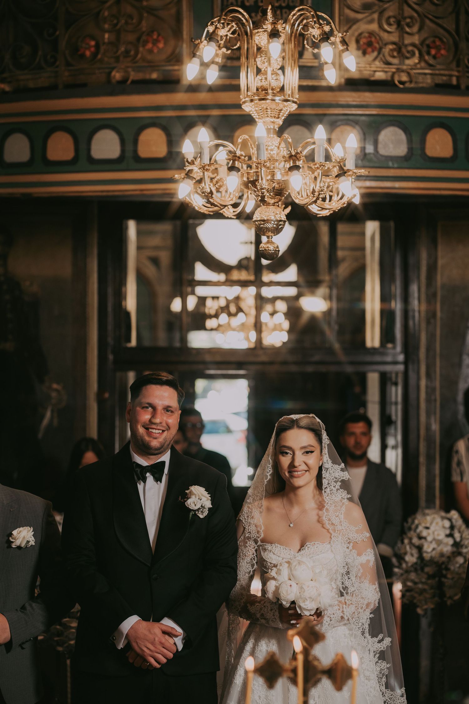 Smiling bride and groom standing together during church wedding ceremony.